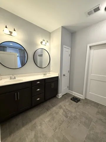 a spacious bathroom with a double vanity sink and a mirror