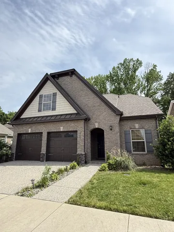 a front view of a house with a garden and yard