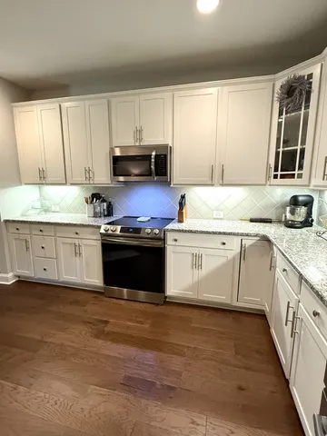 a kitchen with stainless steel appliances granite countertop a stove a sink dishwasher and a refrigerator