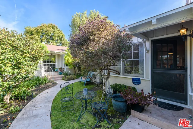 a view of a house with a yard and potted plants