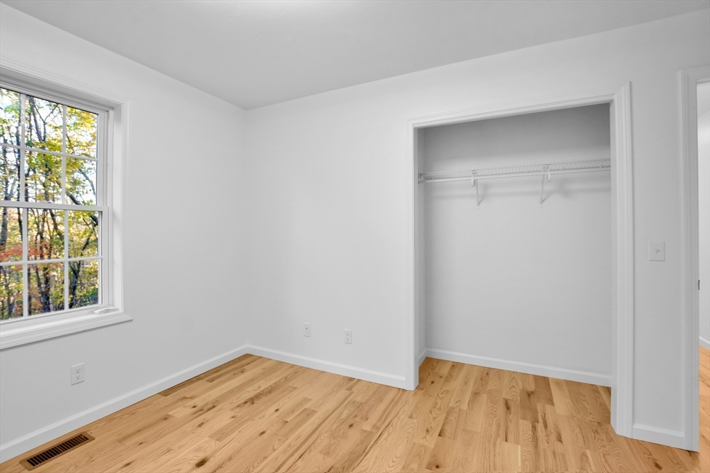76 Number 6 Schoolhouse Road Charlton, MA 01507 - Photo 15 of 29 a view of an empty room with wooden floor and a window