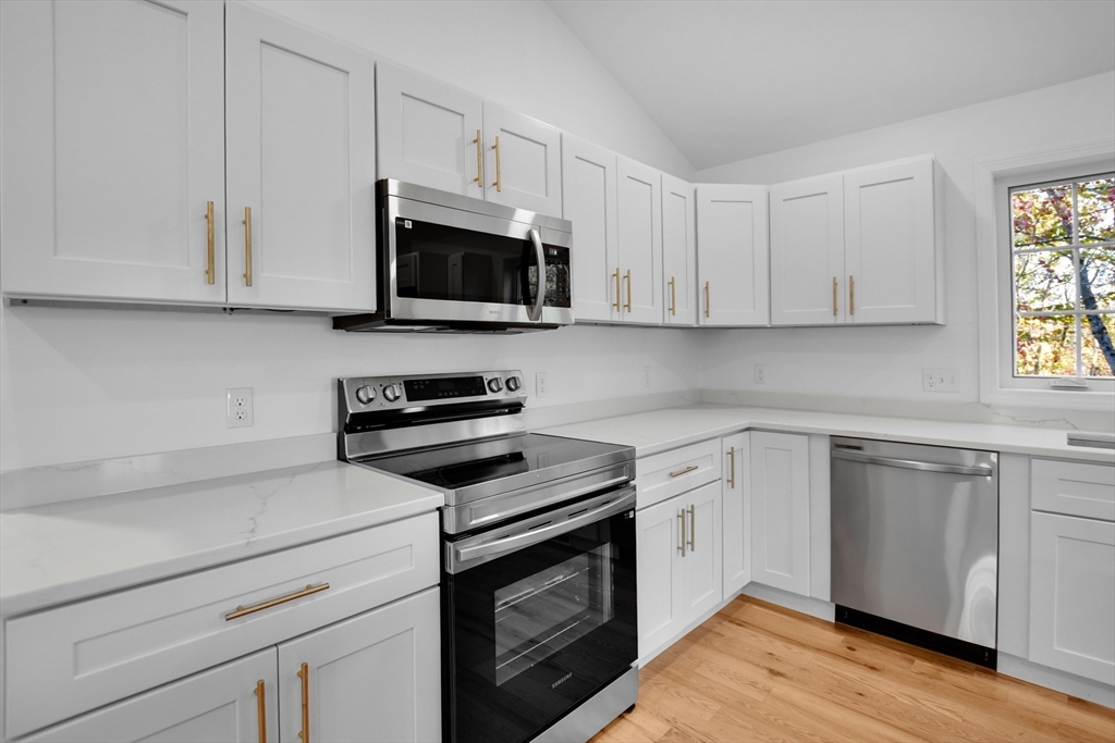 76 Number 6 Schoolhouse Road Charlton, MA 01507 - Photo 4 of 29 a kitchen with cabinets stainless steel appliances and wooden floor