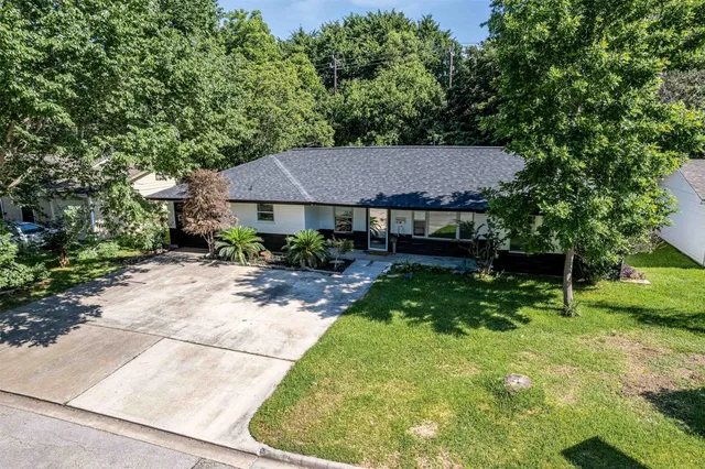 a aerial view of a house with yard and green space