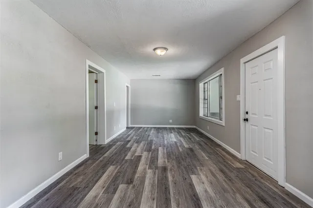 a view of a room with wooden floor and window