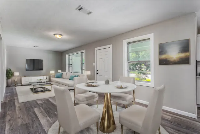 a living room with furniture a flat screen tv and a window
