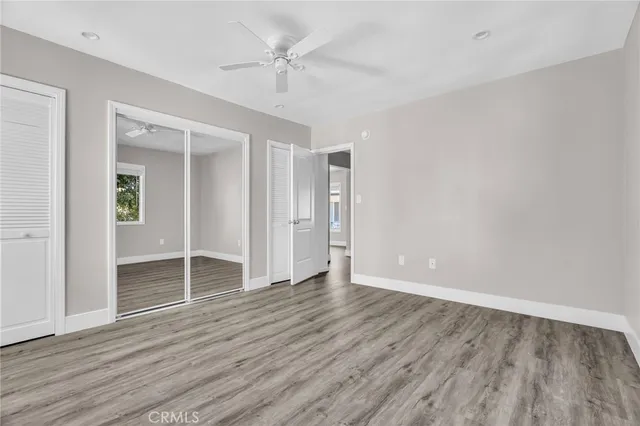 a view of an empty walk in closet and wooden floor