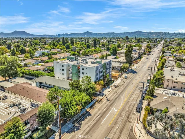 an aerial view of residential houses with outdoor space and street view