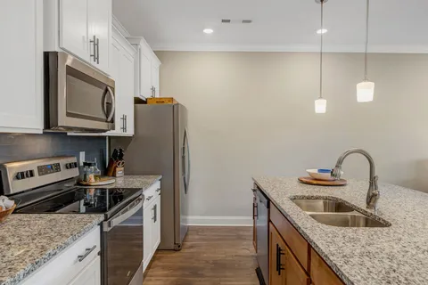a kitchen with sink stove and refrigerator