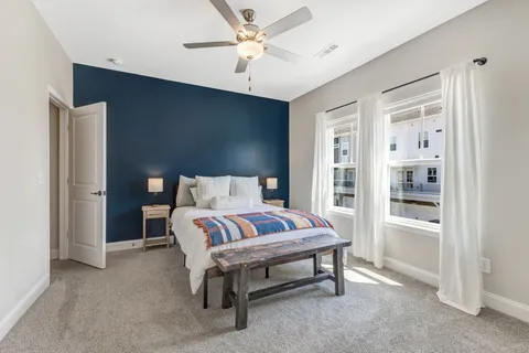 a bedroom with a large bed and a chandelier fan