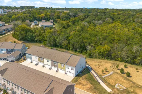 an aerial view of residential houses with outdoor space and river