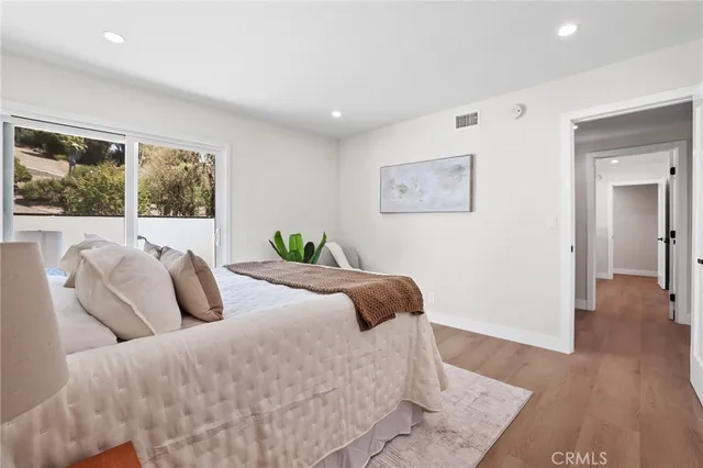 a bedroom with bed and wooden floor