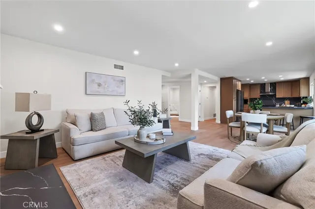 a living room with furniture and view of kitchen