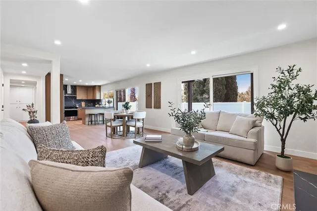 a living room with furniture and a view of kitchen
