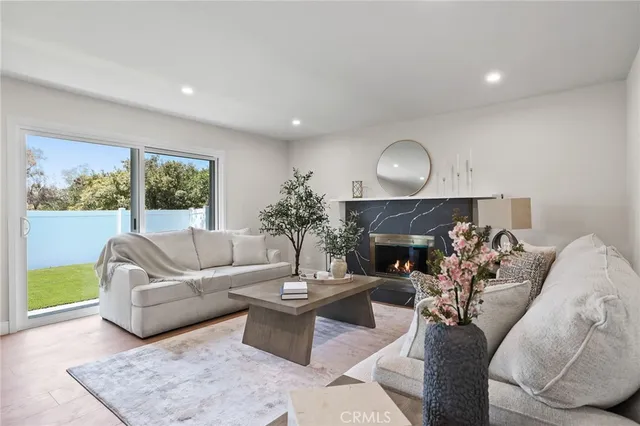 a living room with furniture a fireplace and a large window