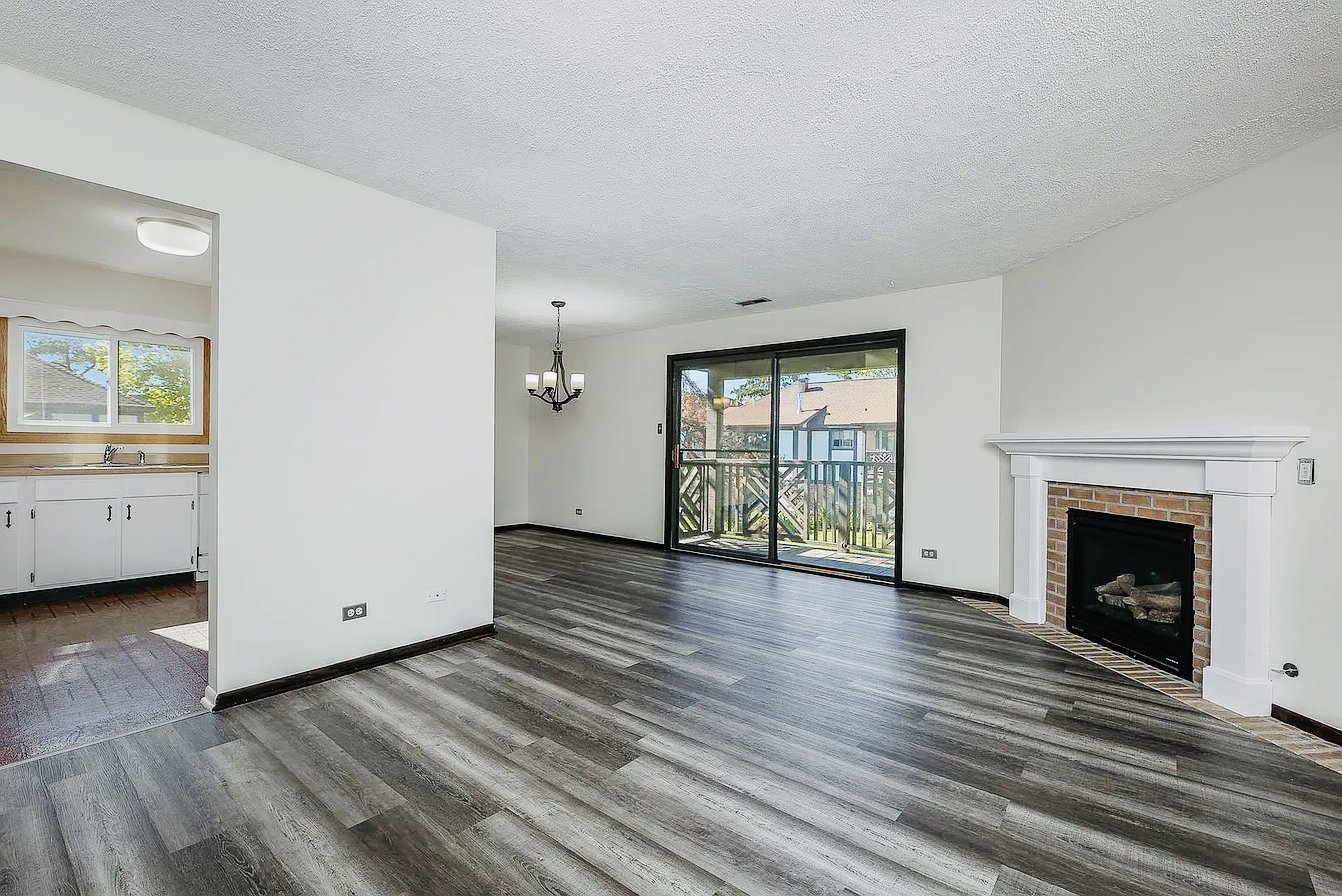 865 Sheldon Court, Unit C Wheaton, IL 60189 - Photo 3 of 11 a view of an empty room with a fireplace and a window