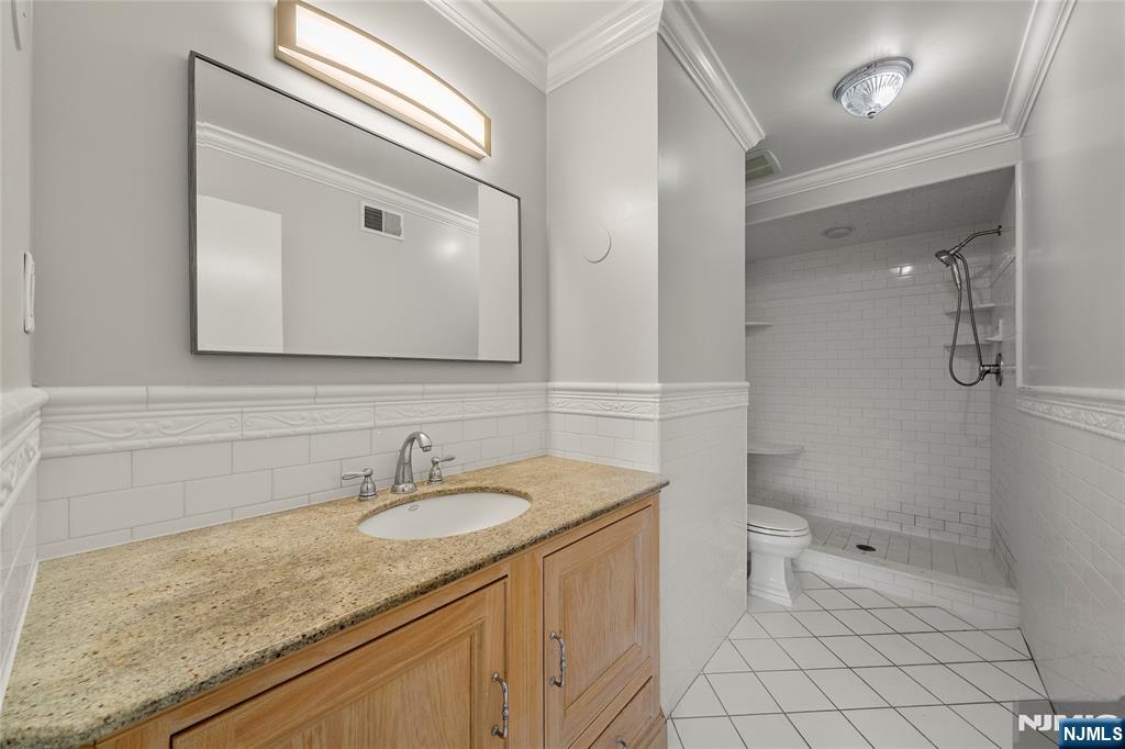 121 Broadway Cresskill, NJ 07626 - Photo 12 of 17 a bathroom with a sink a toilet and a mirror