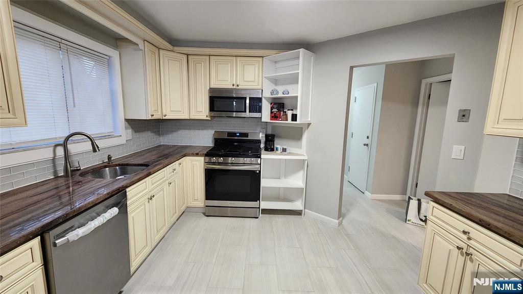 121 Broadway Cresskill, NJ 07626 - Photo 7 of 17 a kitchen with stainless steel appliances granite countertop a stove a sink and a refrigerator