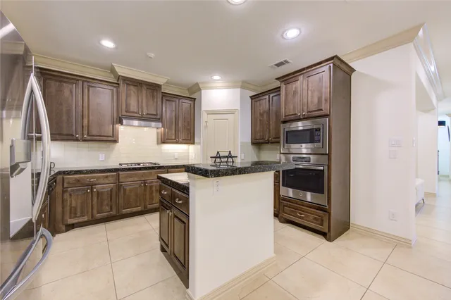 a kitchen with granite countertop stainless steel appliances and wooden cabinets