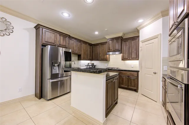 a kitchen with stainless steel appliances granite countertop a refrigerator sink and cabinets