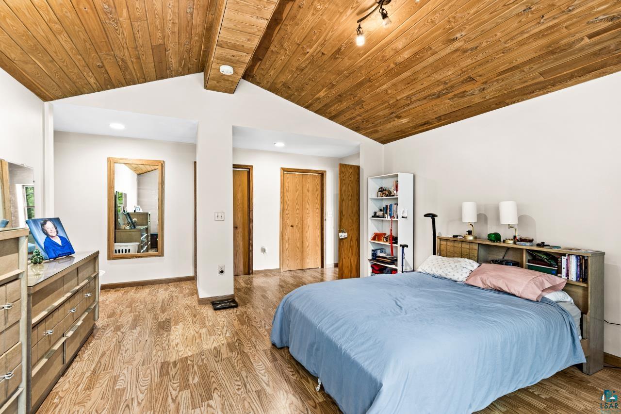 4800 Tower Road Moose Lake, MN 55767 - Photo 21 of 83 Angled wood-paneled ceiling with exposed beams, recessed lighting, and track lighting