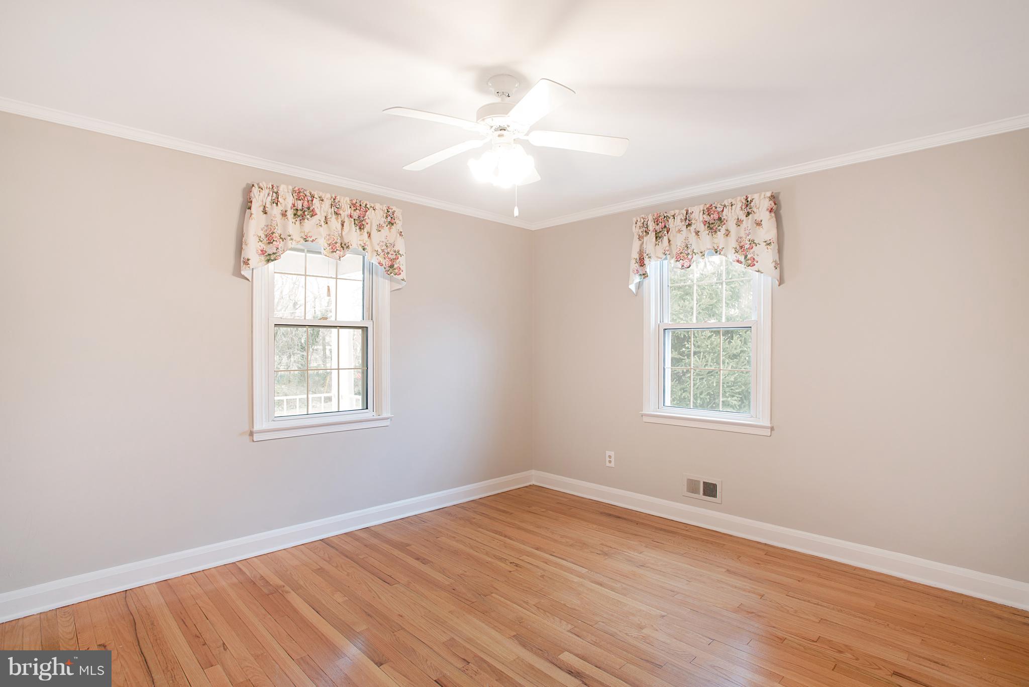 3300 Garnet Road Baltimore, MD 21234 - Photo 16 of 55 an empty room with wooden floor chandelier fan and windows