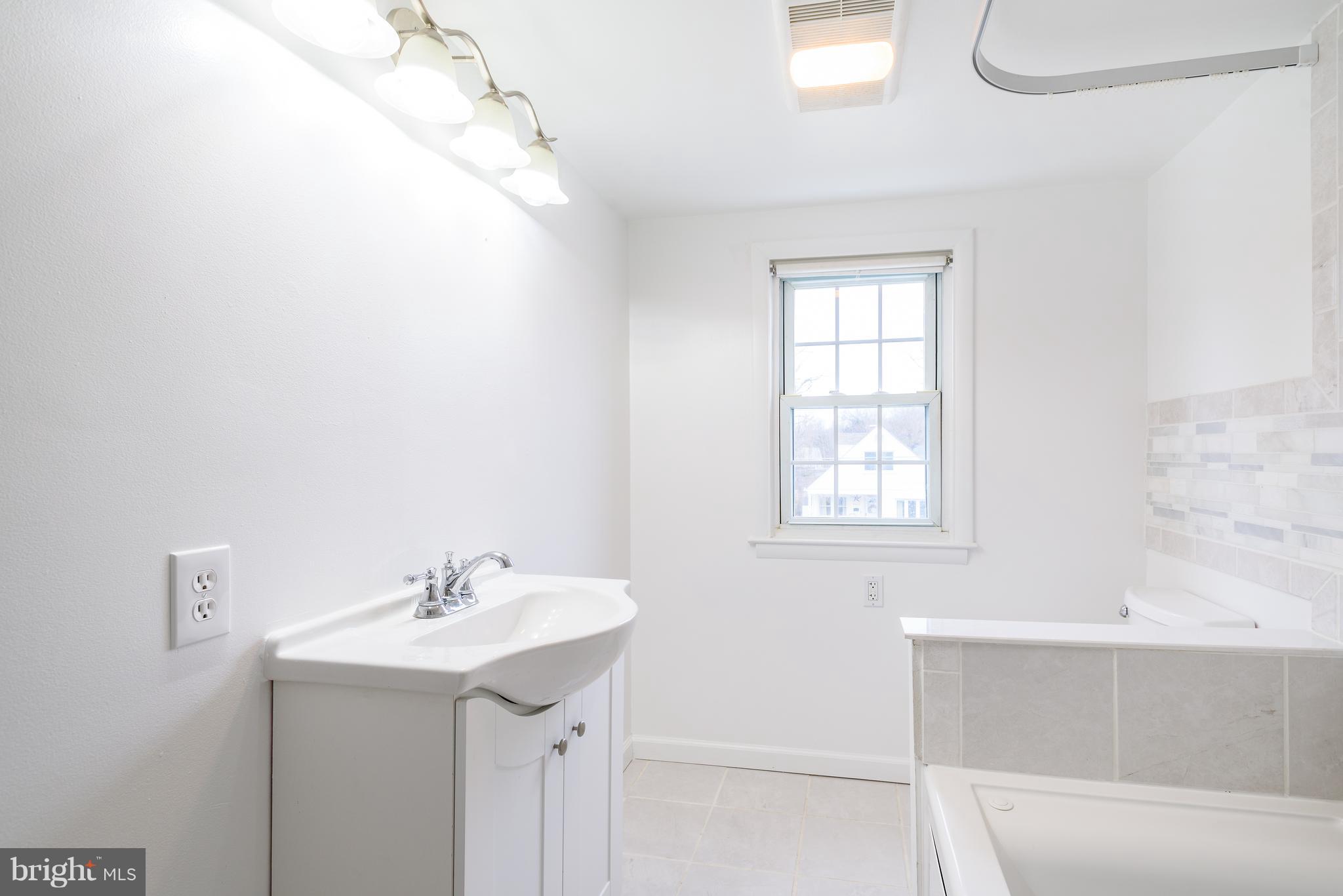 3300 Garnet Road Baltimore, MD 21234 - Photo 49 of 55 a bathroom with a sink a mirror and a bathtub