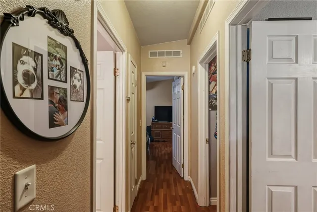 a view of a hallway with wooden floor and a car parked