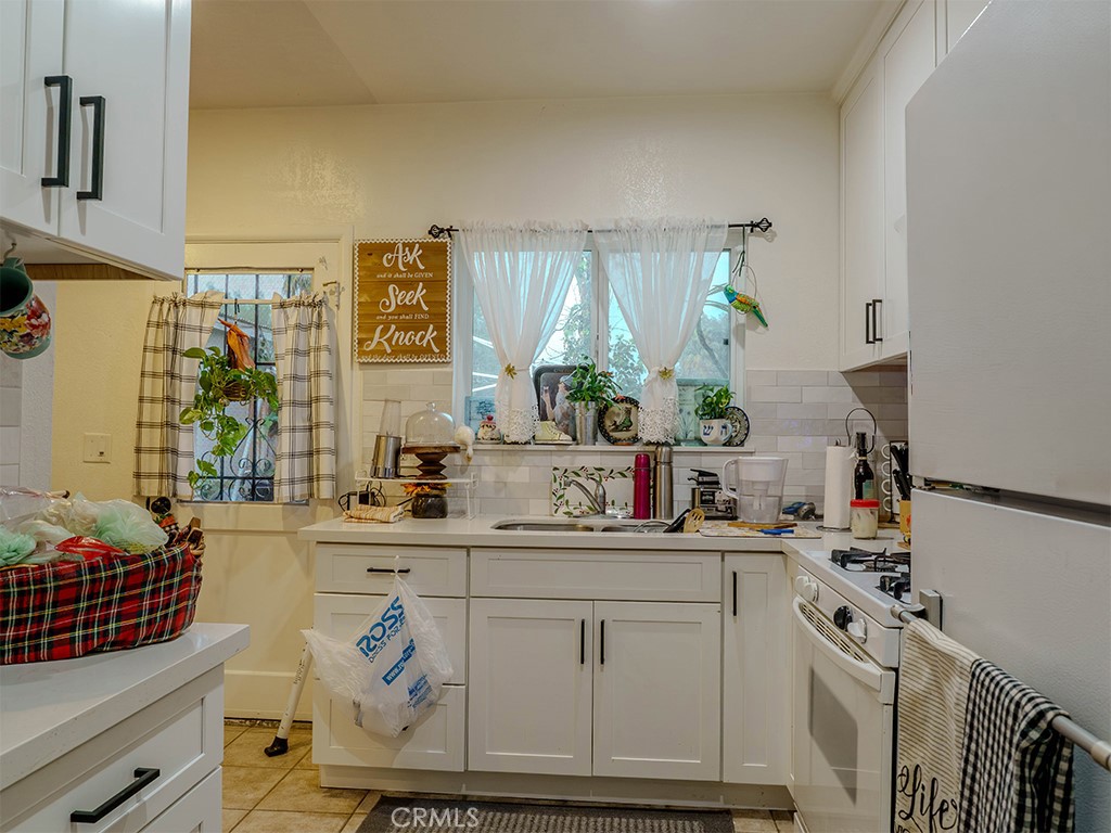9413 Garfield Street Riverside, CA 92503 - Photo 16 of 33 a kitchen with stainless steel appliances a sink a stove and a refrigerator