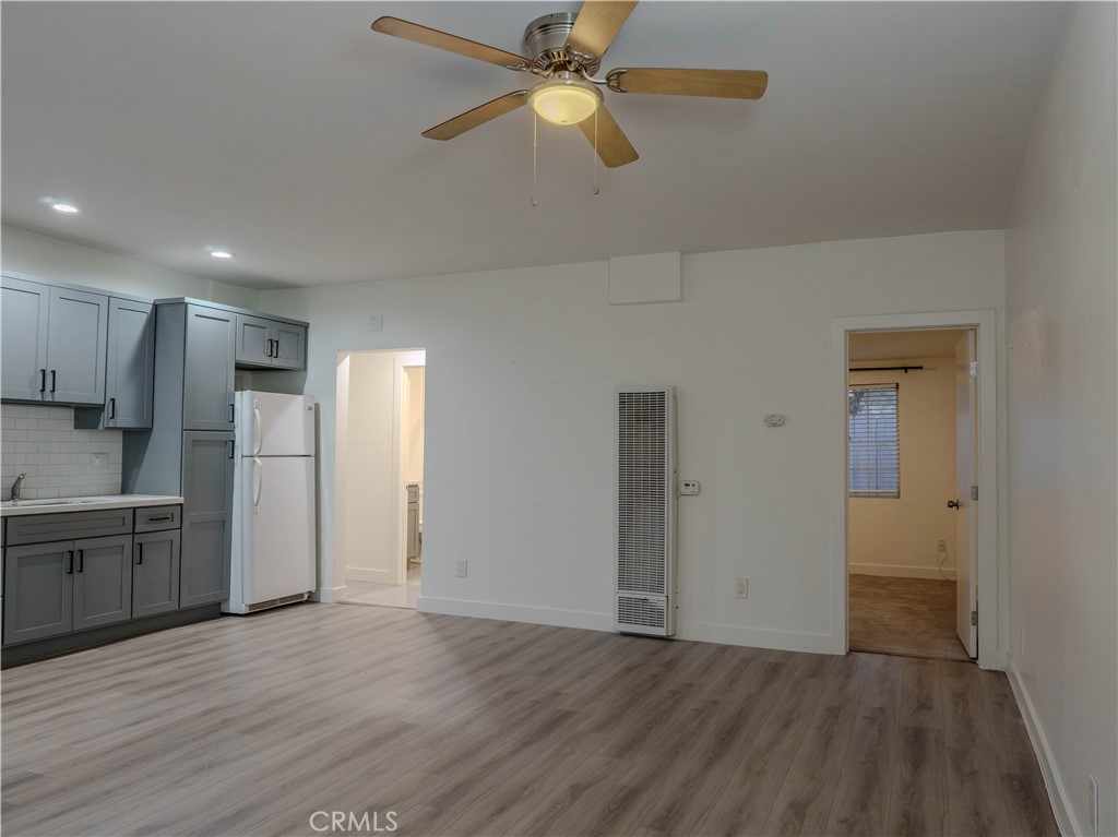 9413 Garfield Street Riverside, CA 92503 - Photo 2 of 33 a view of a kitchen with a refrigerator a ceiling fan and wooden floor