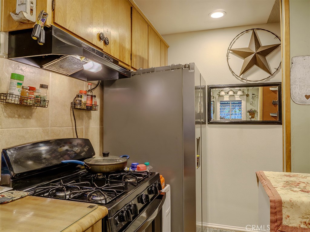 9413 Garfield Street Riverside, CA 92503 - Photo 21 of 33 a kitchen with stainless steel appliances granite countertop a stove and a refrigerator