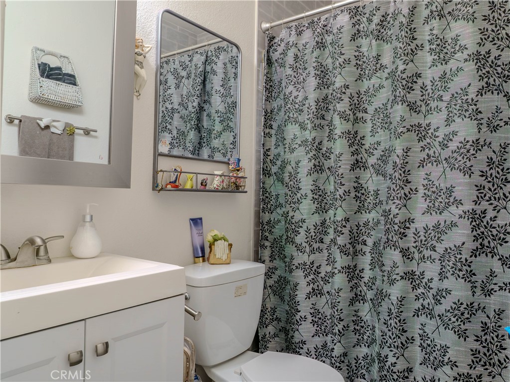 9413 Garfield Street Riverside, CA 92503 - Photo 8 of 33 a bathroom with a toilet sink and mirror