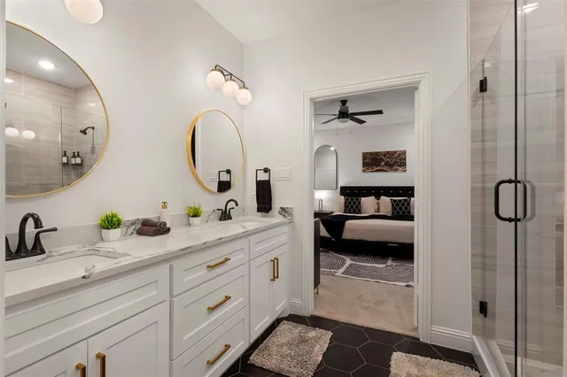 a spacious en suite bathroom with double sink a mirror and shower