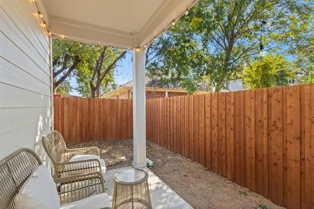 a view of a backyard with a large tree and wooden fence