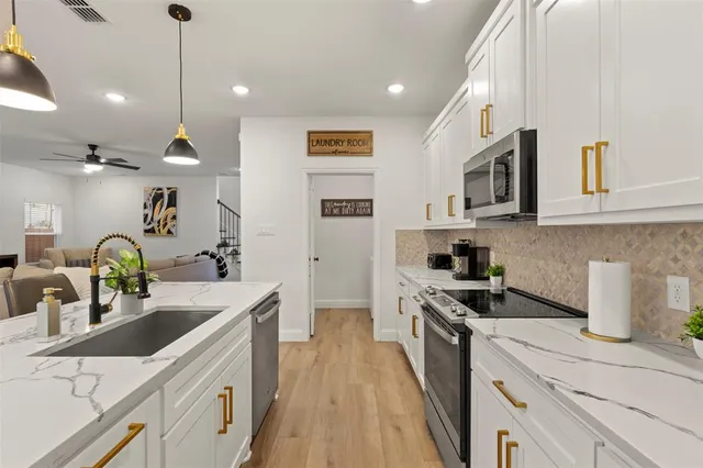 a kitchen with a sink a stove and cabinets