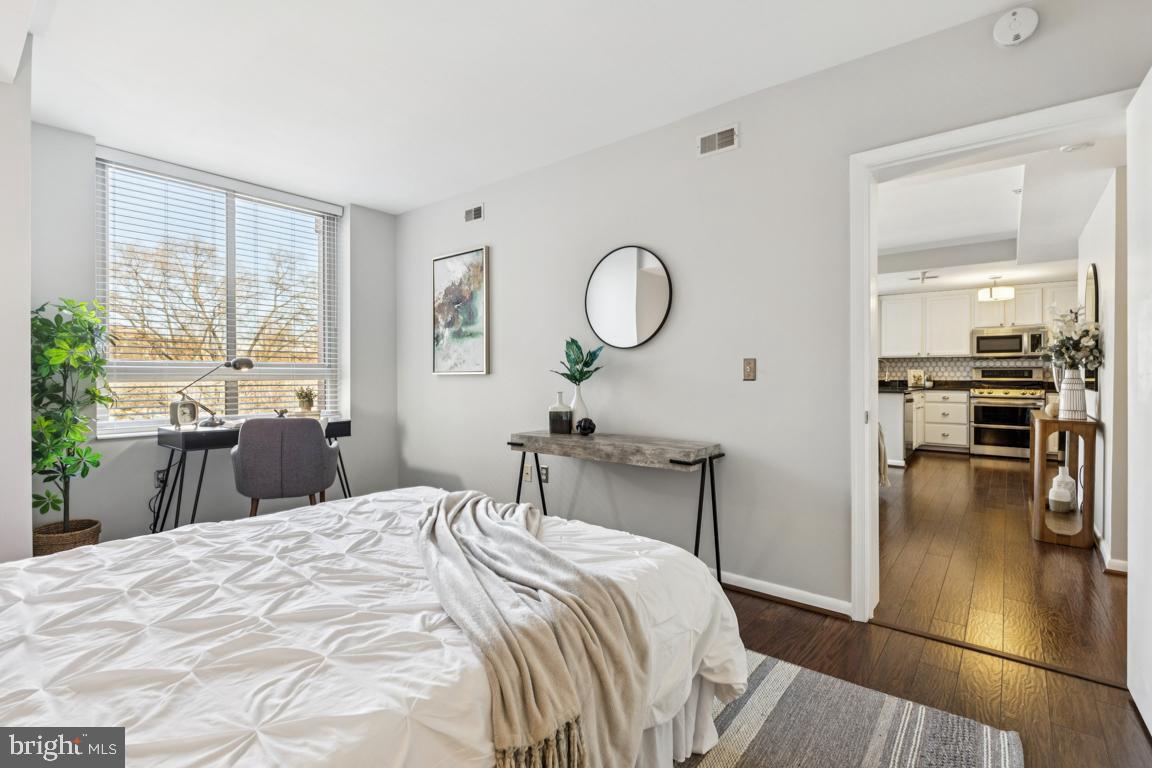 355 I Street Southwest, Unit 501 Washington, DC 20024 - Photo 22 of 44 a bedroom with a bed a table and chair with a large window