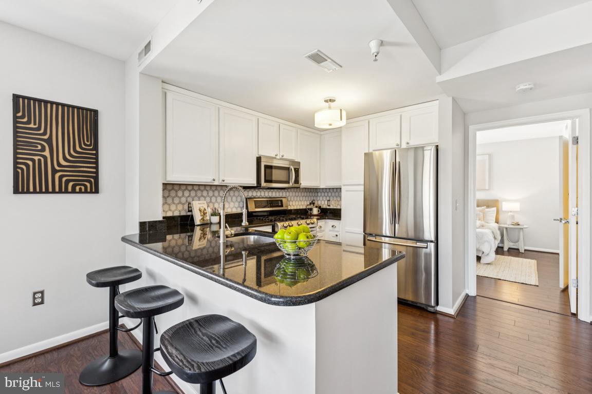 355 I Street Southwest, Unit 501 Washington, DC 20024 - Photo 8 of 44 a kitchen with stainless steel appliances granite countertop a sink stove and refrigerator