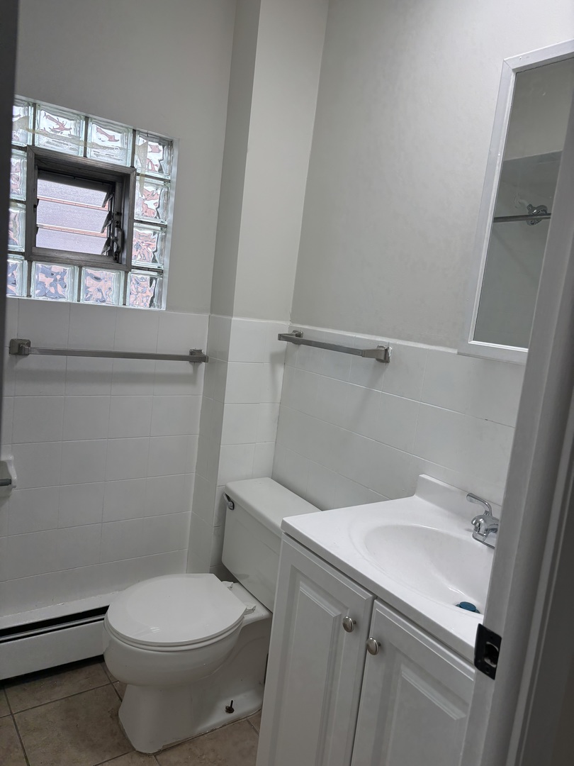 10401 South Ewing Avenue, Unit 2R Chicago, IL 60617 - Photo 7 of 8 a white toilet sitting next to a bathroom sink