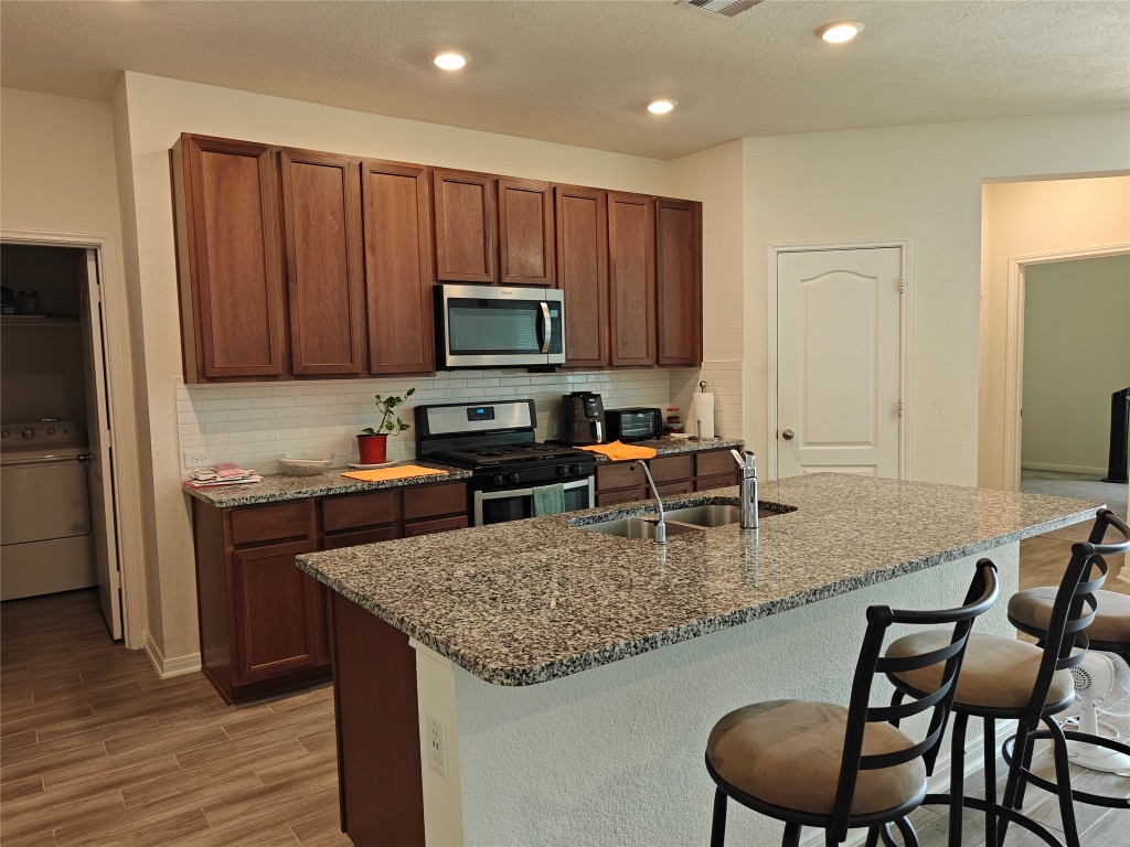 1270 Glendora Drive Rosharon, TX 77583 - Photo 7 of 43 a kitchen with kitchen island granite countertop a stove top oven a sink a microwave a dining table and chairs