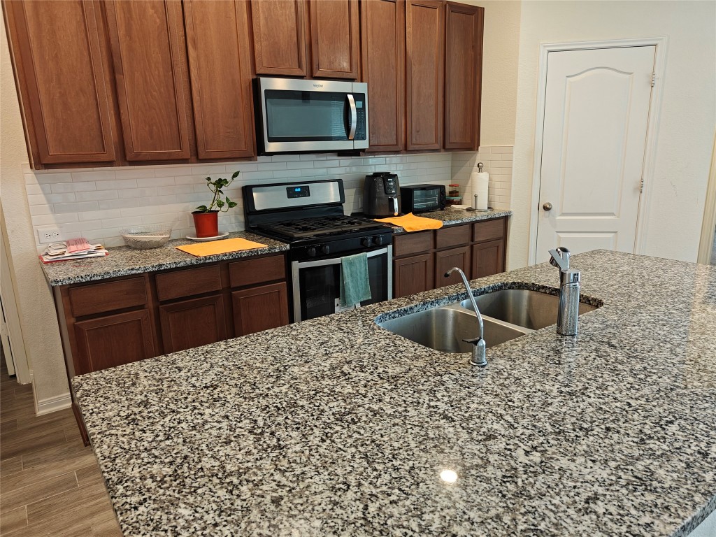 1270 Glendora Drive Rosharon, TX 77583 - Photo 8 of 43 a kitchen with stainless steel appliances granite countertop a sink stove and microwave