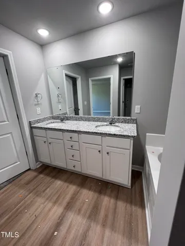 a spacious bathroom with a granite countertop sink and a mirror