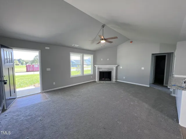 a view of an empty room with window and fireplace