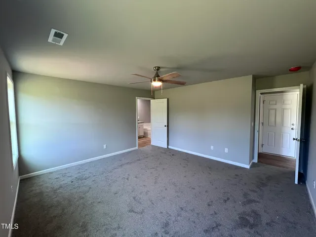 an empty room with closet and a chandelier fan