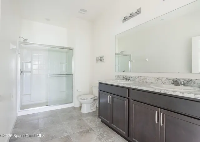 a bathroom with a granite countertop sink a toilet and shower