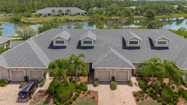 a front view of a house with a yard and potted plants