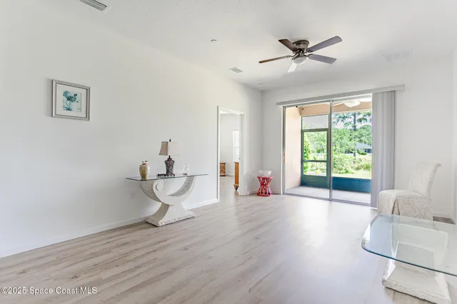 a view of a livingroom with wooden floor and a ceiling fan