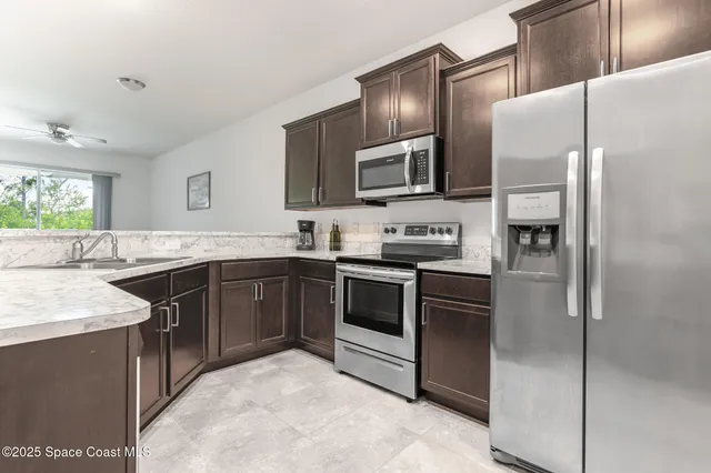 a kitchen with stainless steel appliances granite countertop a refrigerator and a stove