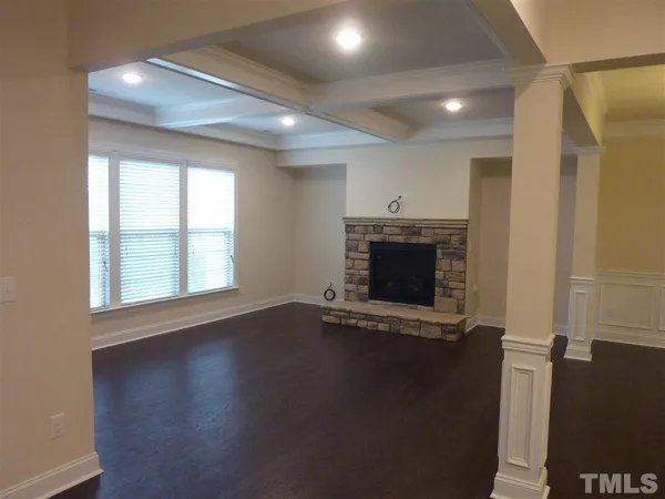 an empty room with wooden floor and a fireplace