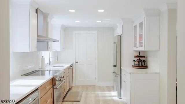 a kitchen with white cabinets and refrigerator