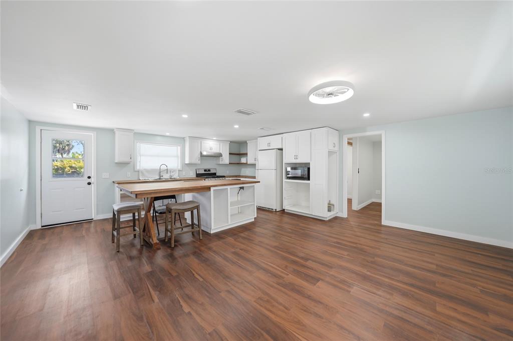 8164 Archie Street Englewood, FL 34224 - Photo 4 of 42 a kitchen with stainless steel appliances kitchen island wooden floors and white cabinets