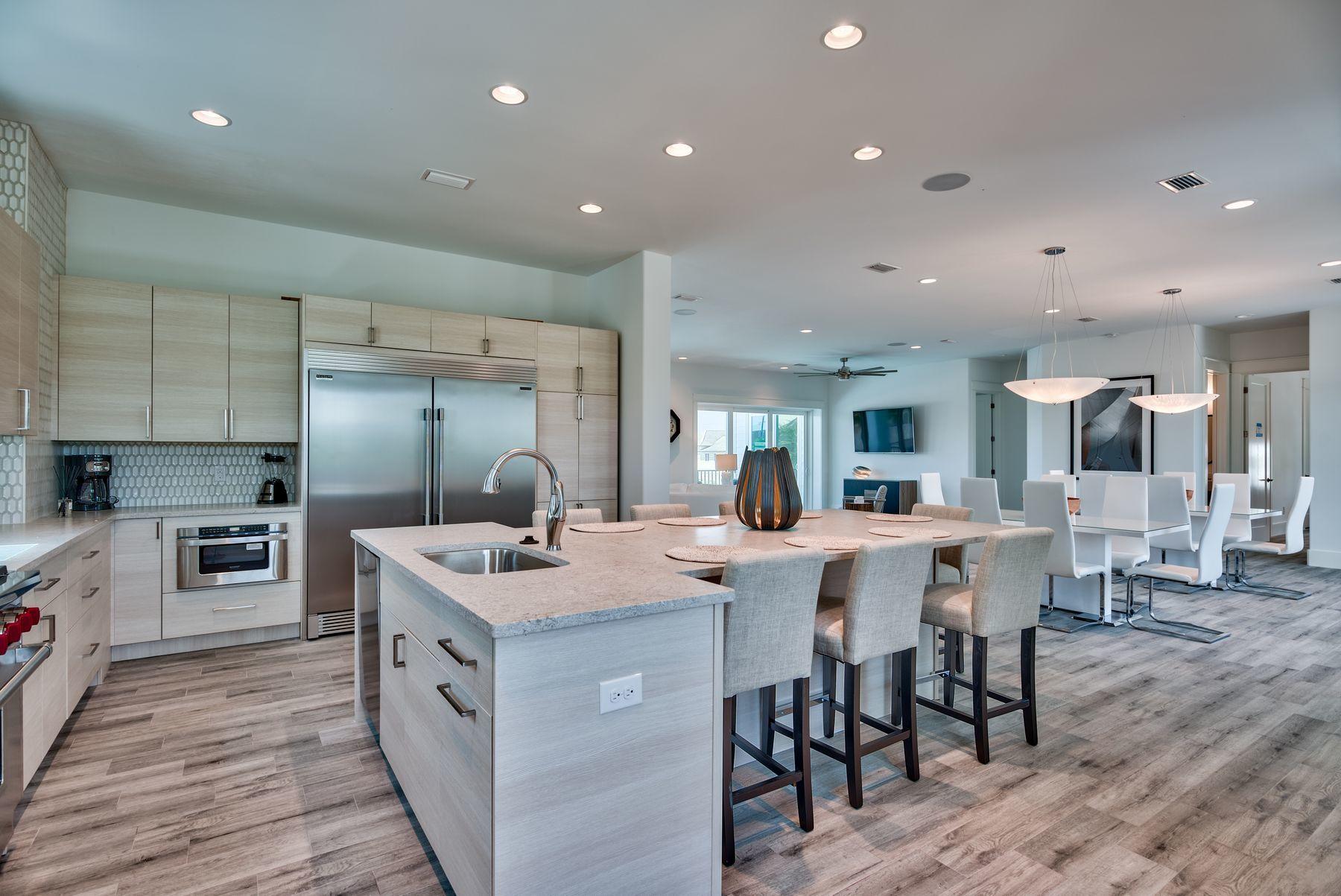 37 West Seahorse Circle Santa Rosa Beach, FL 32459 - Photo 12 of 44 a kitchen with stainless steel appliances kitchen island granite countertop a table chairs sink and cabinets